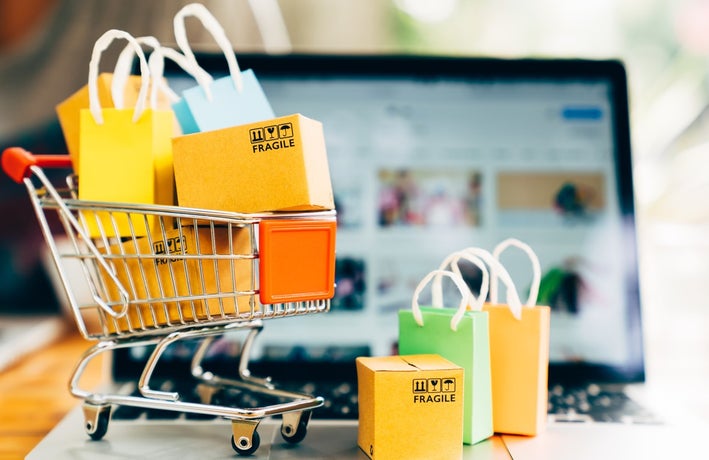 mini shopping trolley full of bags on a computer keyboard