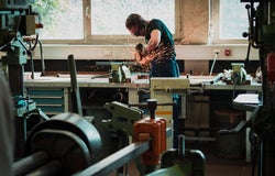 A man using a grinder in a workshop