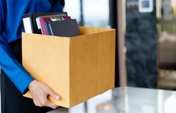 Woman carrying box of possessions out of an office