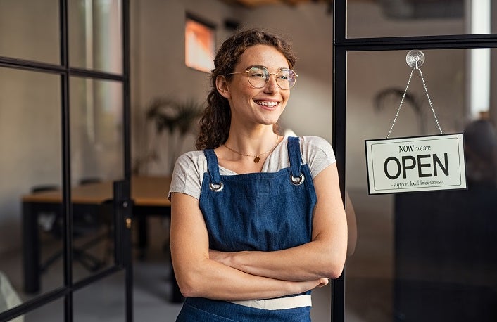 Small business owner standing at cafe entrance