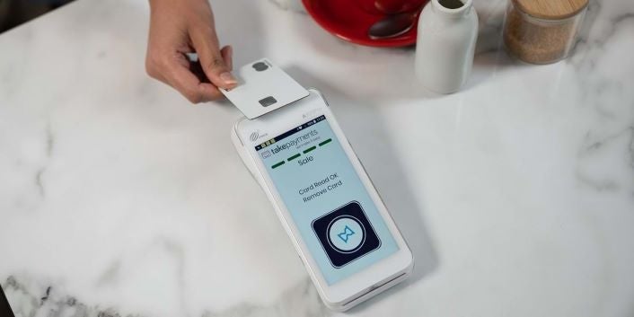 Image of a person tapping their payment card on the takepayments plus card reader